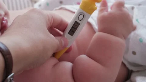 Measure temperature electronic thermometer to upset crying newborn Stock Footage 138077453