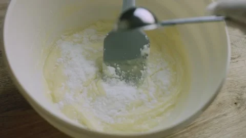 Measured white powder added to the prepared cake mixture Stock Footage 342127798