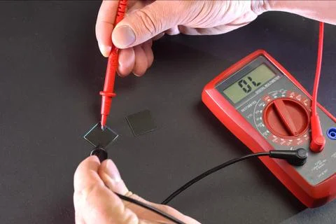 Measurement of product electrical parameters using multimeter. Stock Photos