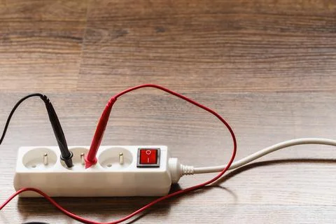 Measurement voltage in electrical socket with multimeter Stock Photos