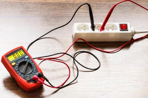 Measurement voltage in electrical socket with multimeter Stock Photos