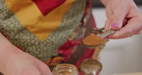 Measuring and leveling cinnamon in measuring spoon Video stock 249314827
