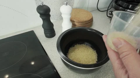 Measuring and Pouring Dry Rice into a Cooking Pot Stock Footage 334249606