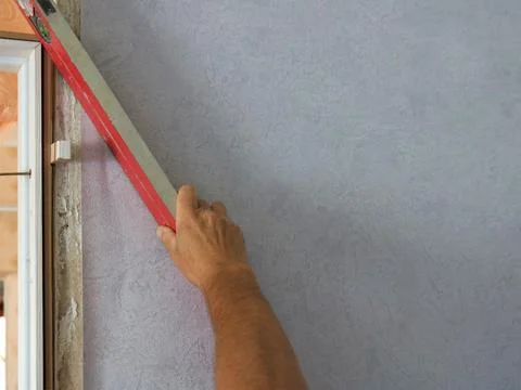 Measuring the angle with a level on a room wall and copy space Stock Photos