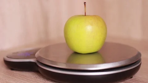 Measuring apple on kitchen scales Stock Footage 81584640