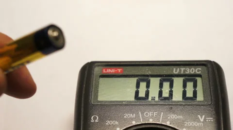 Measuring battery voltage using the digital multimeter Stock Footage 37802929