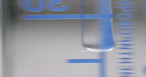 Measuring Beaker with Water being Stirred by Glass Rod inside Chemical Stock Footage 322602585