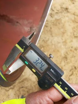 Measuring the beveling dimensions of the end pipe with a caliper Stock Photos