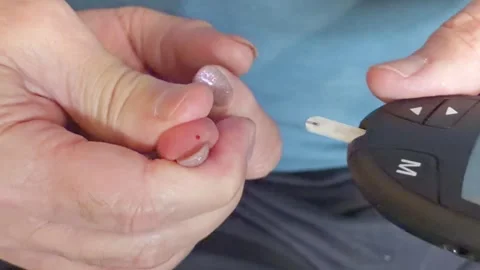 Measuring blood sugar level with glucometer, blood drop on finger, close up Stock Footage 336402717