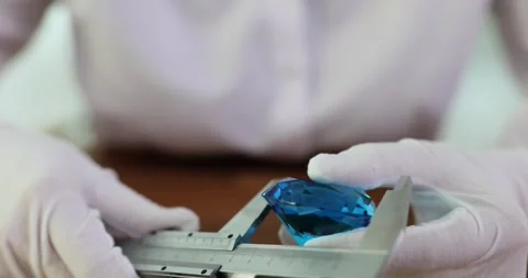 Measuring blue diamond in hands of gemologist Stock Footage 253498925