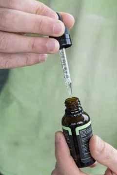 Measuring the correct amount of cbd oil from a brown tincture bottle. Stock Photos