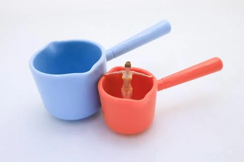 Measuring Cups with Tiny Figurine for Conceptual Playful Design Stock Photos