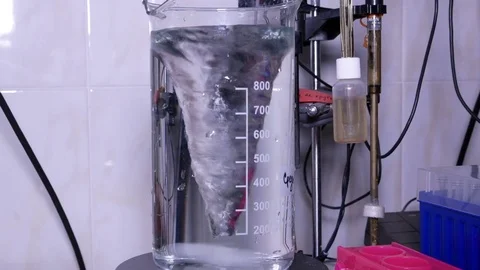 Measuring cylinder with a solution on a magnetic stirrer Video stock 84224934