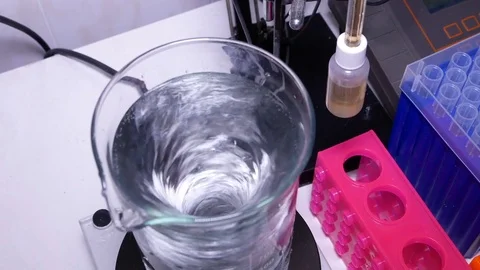 Measuring cylinder with a solution on a magnetic stirrer Video stock 84225080