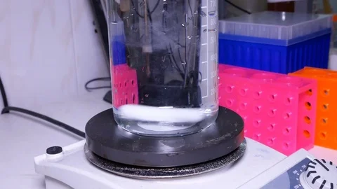 Measuring cylinder with a solution on a magnetic stirrer Stock Footage 84225335