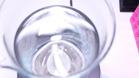 Measuring cylinder with a solution on a magnetic stirrer Video stock 84225459