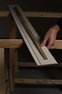 Measuring decorative wall panel board with folding ruler by hand before cutti Stock Photos