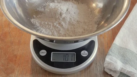Measuring Flour in a Mixing Bowl With a Digital Scale to Bake a Cake - 4K Stock Footage 76614965