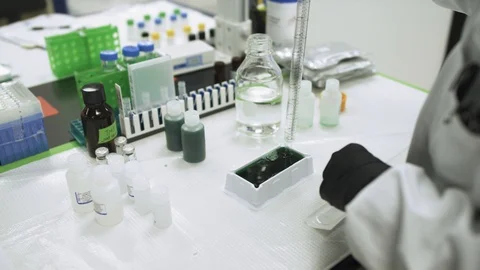 Measuring green liquid in scientific lab looking for a cure to a virus Stock Footage 127532707