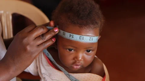 Measuring the head circumference of a child using a tape meter. 스톡 동영상 96916578