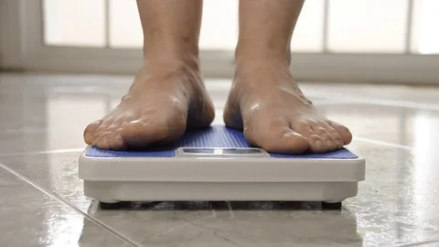 Measuring her weight Stock-Footage 69990929