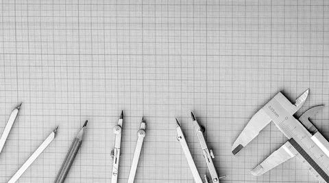 Measuring instruments on top of white graph paper. Stock Photos