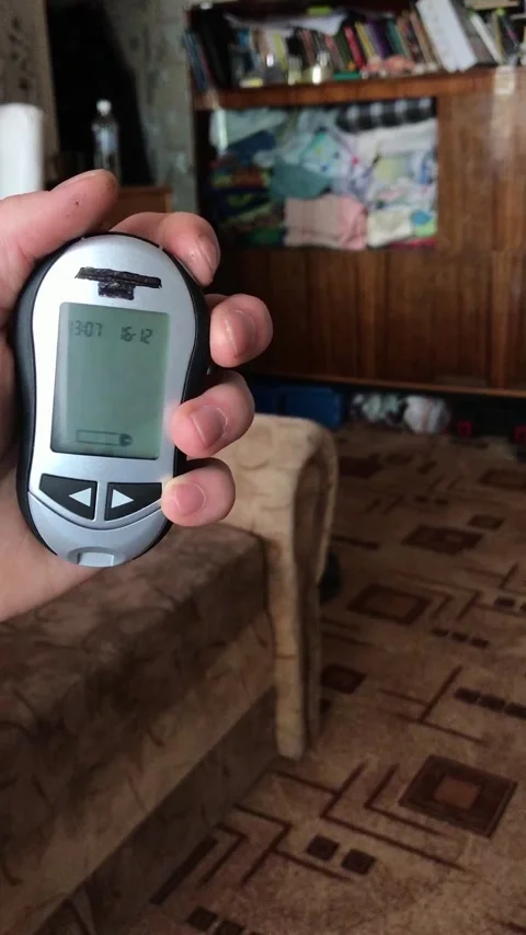 Measuring insulin levels with a handheld device in a living room Stock Footage 308368650