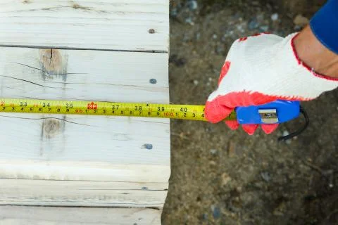 Measuring the length with a construction tape. Stock Photos