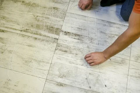 Measuring the length of electric wire lying on the floor. Stock Photos