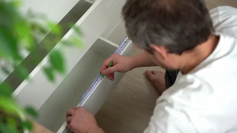 Measuring the length with tape measure, assembling, installing wooden furniture Stock Footage 256067390