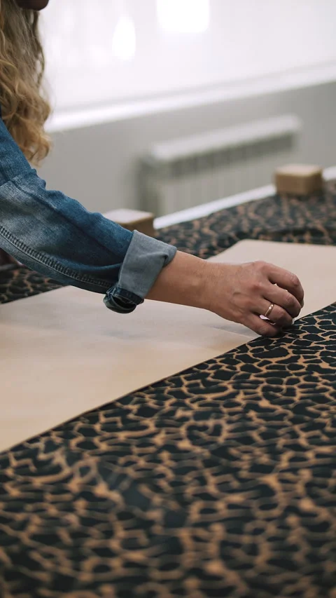 Measuring leopard print fabric with measuring tape Stock Footage 308723674