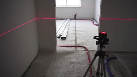 Measuring the level in the apartment with a laser Stock Footage 257014882