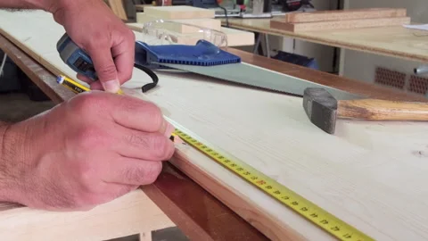 Measuring long timber board with hand saw in background Stock Footage 335679842