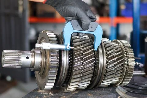 Measuring Manual Transmission Gear Components with Micrometer. Stock Photos