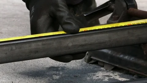 Measuring metal pipe and cutting it off with a lots of sparks, Dolly shot Stock Footage 72763445