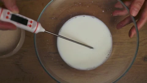 Measuring milk temperature with digital kitchen thermometer Stock Footage 308321172
