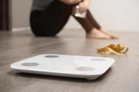 Measuring scale amid distressed upset girl. concept that you need to measure  Stock Photos