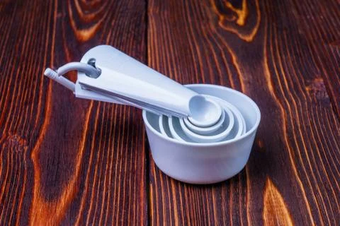 Measuring set table spoons and cups plastic white color on woode Stock Photos