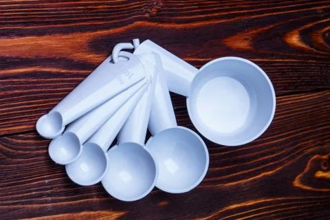 Measuring set table spoons and cups plastic white color on woode Stock Photos
