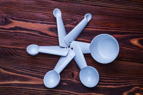 Measuring set table spoons and cups plastic white color on woode Stock Photos