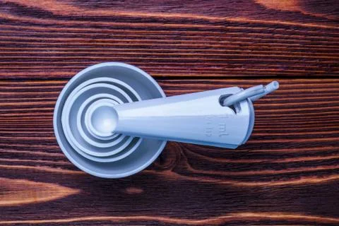 Measuring set table spoons and cups plastic white color on woode Stock Photos
