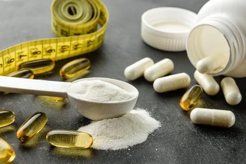 Measuring spoon with creatine close-up. Creatine, BCAA capsules and omega-3 o Stock Photos