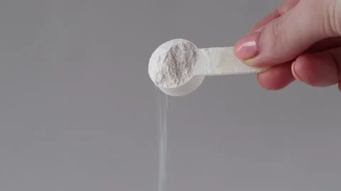 A measuring spoon with electrolyte powder and sports nutrition on a gray Stock Footage 234163827