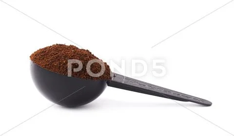 Measuring spoon filled with coffee over isolated white background Stock Photos