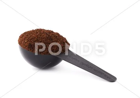 Measuring spoon filled with coffee over isolated white background Stock Photos