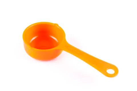 Measuring spoon or cup over the white background. Stock Photos