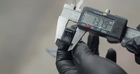 Measuring a switch’s width with caliper for precise installation or replacement. Stock Footage 312949450