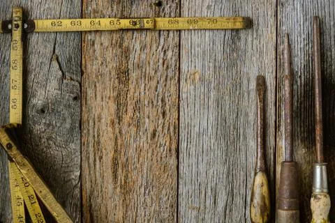 Measuring tape and screwdriver on rustic old wood background Foto stock