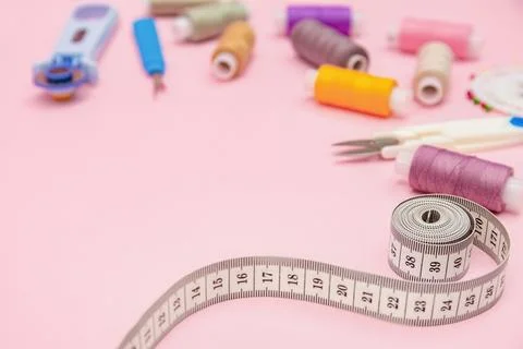 Measuring Tape and Sewing Threads on Pink Tailor Desk Stock Photos