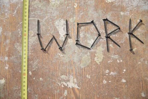 Measuring tape and the word work on the wooden table Stock Photos